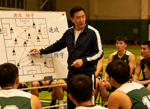 教练在战术板上布置球队阵型与跑位路线